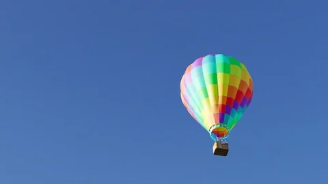 "Vibrant, multi-colored hot air balloons against bright blue cloudless sky." Stock Footage 97959458