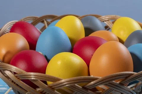 Vibrant Multi-Colored Painted Easter Eggs Arranged in a Traditional Wicker .. Stock Photos