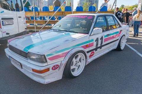 A vibrant multi-colored race car pink, blue, purple with number 1, parked on  Foto stock