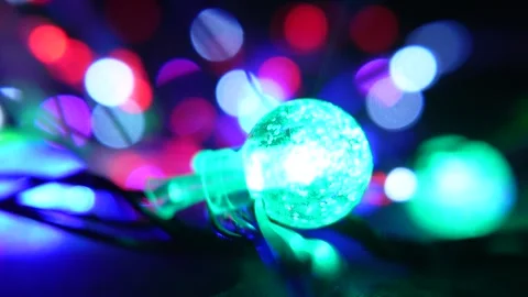 Vibrant multicolor string lights with glowing red and green bulb accents against Stock Footage 321549477