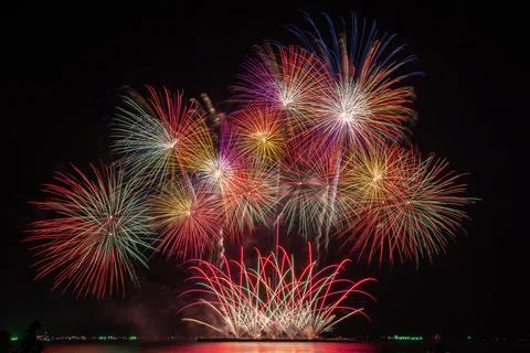 Vibrant Multicolored Fireworks Exploding Over Dark Sea At Night Long Exposu.. Stock-Fotos
