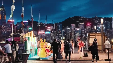 The vibrant night scene in the bustling Tsim Sha Tsui area by the Victoria Stock Footage 338280339