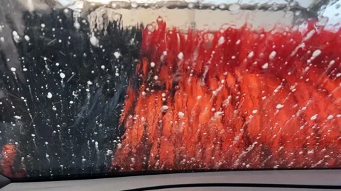 Vibrant Orange and Black Brushes Clean Car Windshield at Automatic Car Wash Stock Footage 334572879