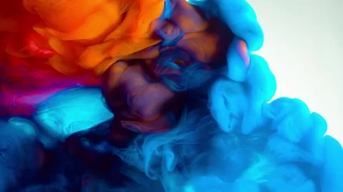 Vibrant orange and blue ink clouds swirling in clear liquid slow motion. Stock Footage 346610486