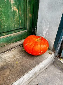 Vibrant orange pumpkin as a rustic autumn welcome on a wooden doorstep Stock Photos