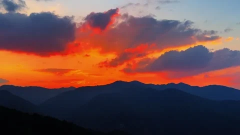 Vibrant Orange Sunset and Dark Mountain Silhouettes Stock Footage 334053854
