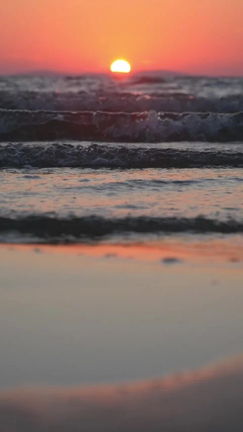 Vibrant orange sunset glows warmly over gentle ocean rolling waves. Stock Footage 337413392