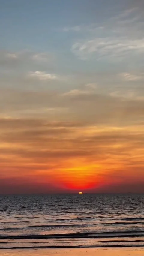Vibrant Orange Sunset Over a Calm Sea and Sandy Beach Stock-Footage 342264324
