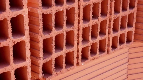 Vibrant orange terracotta bricks stacked on a pallet at a construction site.. Stock Footage 317645556
