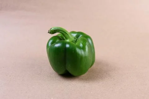 A vibrant overhead shot capturing a single green bell pepper placed centrally Stock Photos