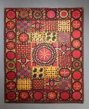 Vibrant patchwork quilt textile featuring bold red, yellow and blue hues Stock Photos