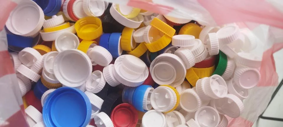 Vibrant pile of assorted plastic bottle caps in various colors like white, .. Stock Photos