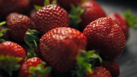 Vibrant pile of freshly picked red strawberries lies on a rustic wooden tabl Video stock 338187566
