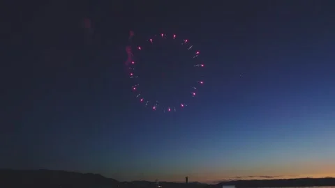 Vibrant pink ring firework blooming in deep blue dusk sky Stock Footage 340632668