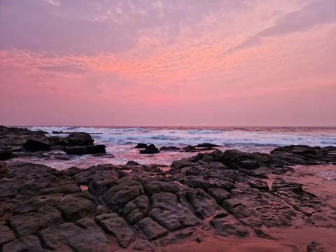 Vibrant Pink Sunset over Thompson Bay Rocky Shoreline in Ballito, South Africa. Stock Photos