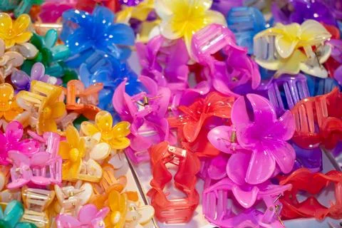 Vibrant plastic flower hair claw clips piled in retail basket. Stock Photos
