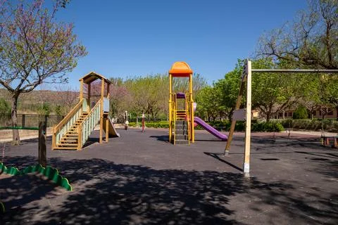 Vibrant playground featuring various slides and swings is nestled in sunny pa Stock Photos