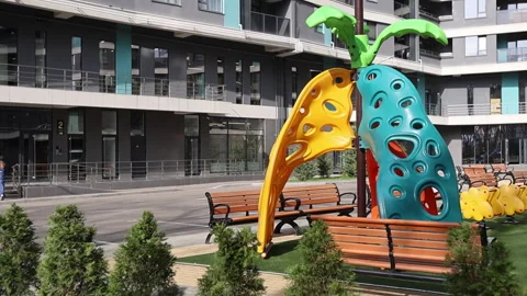 A vibrant playground in a park with colorful structures and a bench Stock Footage 307932753