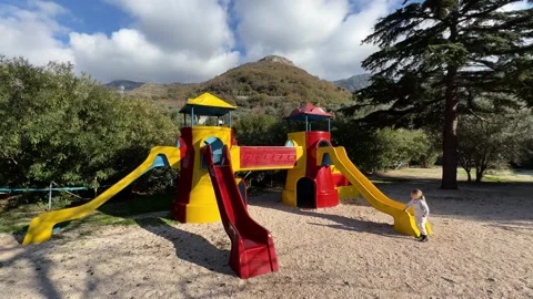A vibrant playground with slide and tower in park under the blue sky Stock Footage 267353328