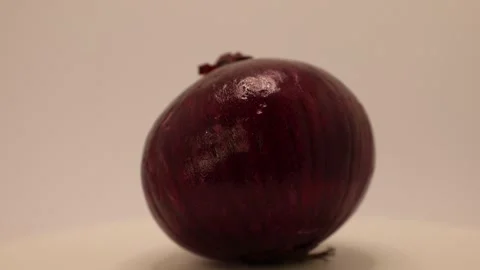Vibrant presentation of a fresh, beautifully crafted red onion highlights its ri Stock Footage 328634608