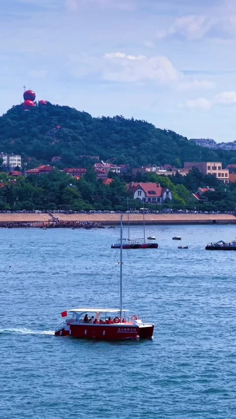 Vibrant Qingdao Harbor: Boats, Cityscape, and Signal Hill Stock Footage 330895953