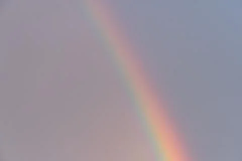 Vibrant rainbow arc against a light background, deep blues to warm reds, sign Stock Photos