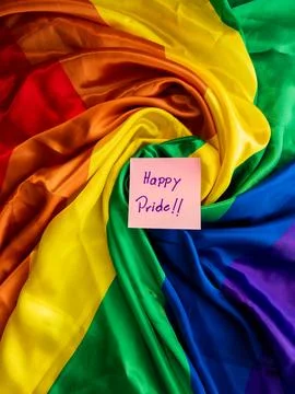 A vibrant rainbow flag with a handwritten note, love, and support for the LGBTQ Stock Photos