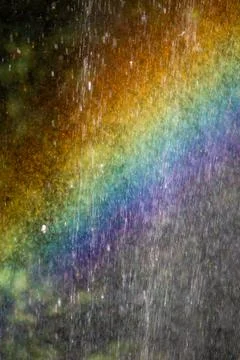 Vibrant rainbow light spectrum refracting through dense water spray droplet.. Stock Photos