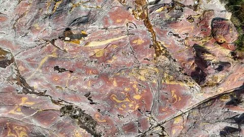 Vibrant raspberry and ochre waves flow across the rock Foto stock