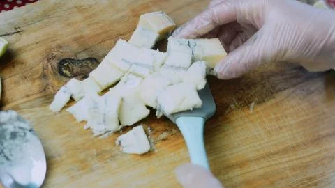 Vibrant recipe study: adding cheese cubes to hot cream Foto stock