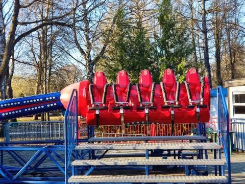 Vibrant red amusement park ride against a background of winter trees Foto stock
