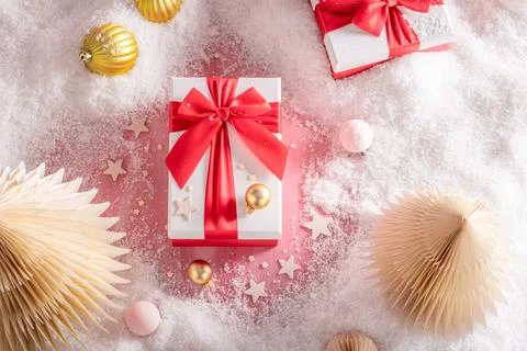 Vibrant red gift parcel styled with festive baubles. Stock Photos