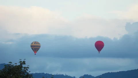 Vibrant red multicolored striped hot air balloons ascend peacefully through Stock Footage 318201886