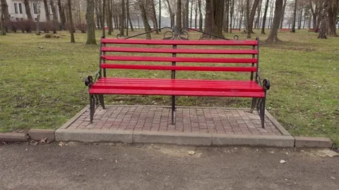 A Vibrant Red Park Bench Set in a Serene and Beautiful Green Space, Awaiting Stock Footage 305268010