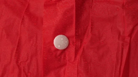 Vibrant red raincoat showcasing its ability to repel water droplets Stock Footage 292263959