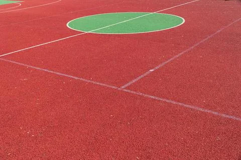 The vibrant red sporting surface features large green circles, ideal for va.. Stock Photos