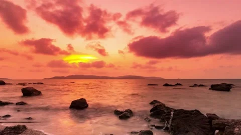 Vibrant Red Sunset over Ocean with Rocky Shore Video stock 310216250