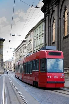 A Vibrant Red Tram Navigating Through a Historic Urban Landscape Rich with Stock Photos