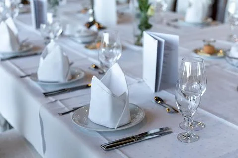 A vibrant restaurant table setting shows neatly arranged plates with folded n Stock Photos