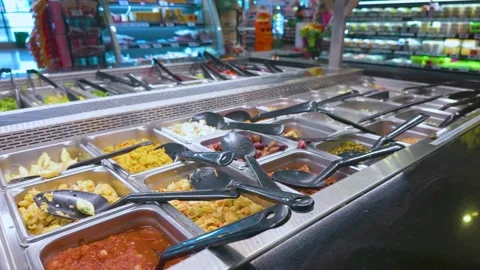 A vibrant salad bar featuring a variety of fresh ingredients in a grocery store Stock Footage 316623935