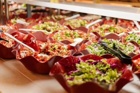 A vibrant salad bar is filled with an array of fresh vegetables and garnishes Stock Photos