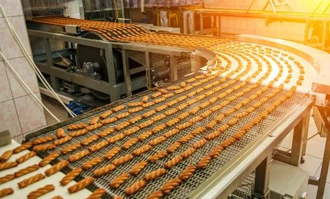 A vibrant scene captures the biscuit assembly line, where perfectly baked goo Foto stock