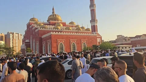 A vibrant scene on Eid day, with a crowd of people gathered outside a beautiful Stock Footage 311764930