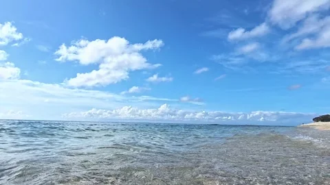 Vibrant Sea Waves Sweeping the Beach Under a Bright Blue Sky in 4K Slow Motion Video stock 287979839