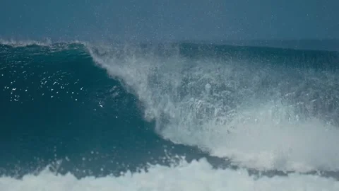 Vibrant Seascape Featuring Towering Wave Curling Under Sunny Sky With Foam Stock Footage 324827315