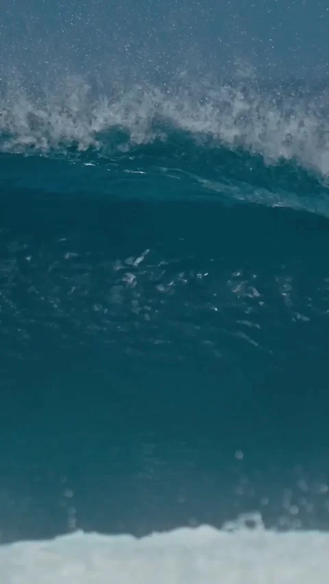 Vibrant Seascape Featuring Towering Wave Curling Under Sunny Sky With Foam Stock Footage 327237500