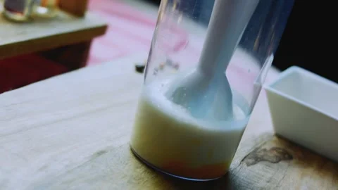 Vibrant serving study of cracking eggs into a tall mixing cup Stock Footage 342154023