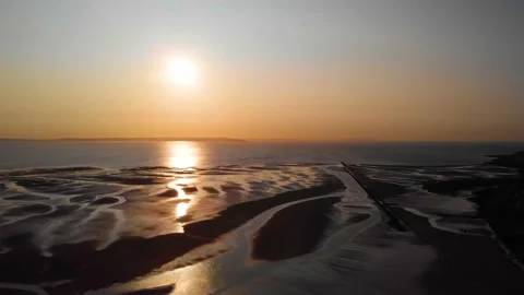 Vibrant sky gradient at sunset reflecting onto beach tidal pools, Wales. Stock Footage 141020775