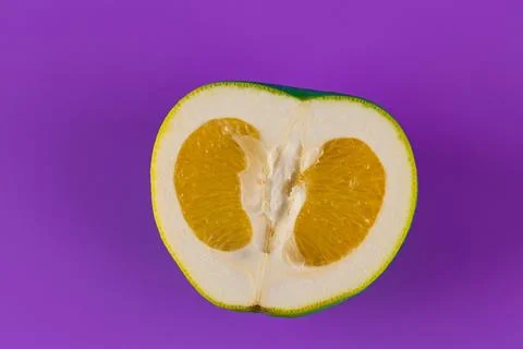 A Vibrant Slice of Fruit Displaying a Unique Color Combination on a Purple Stock Photos