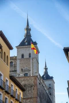A vibrant Spanish flag waves in the wind against a blue sky Stock Photos